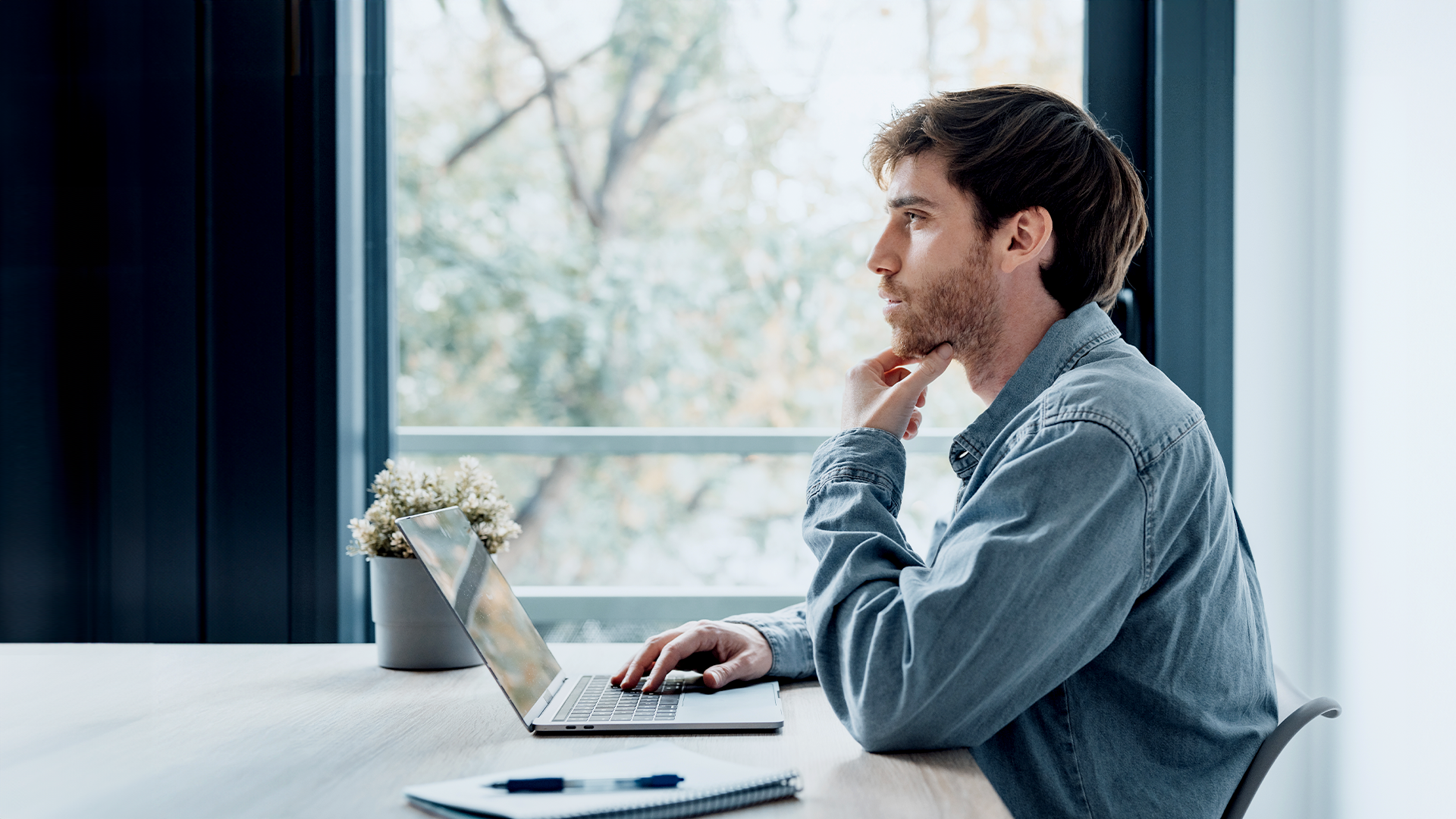 Mann sitzt am Notebook im Büro